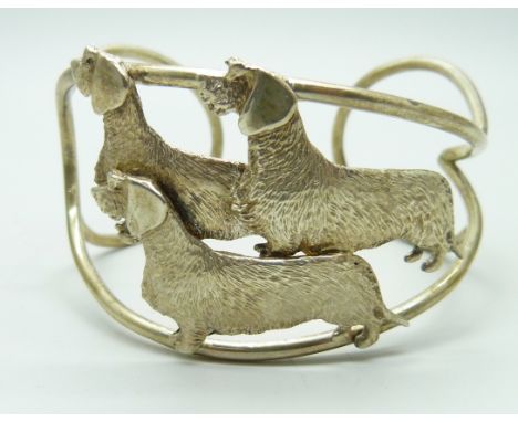 A silver cuff bangle with three wired hair dachshund detail 