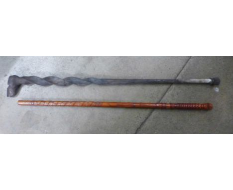 Two novelty walking canes, one dated 1989 and carved with miners head, miners lamp, pick axe and shovel and various belts and