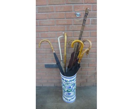 A ceramic stick stand with a collection of six umbrellas, and three walking sticks **PLEASE NOTE THIS LOT IS NOT ELIGIBLE FOR