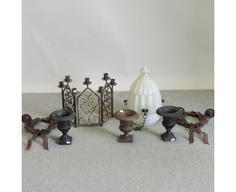An iron open work firescreen, together with three metal campana shaped urns, a pair of wreath shaped wall sconces and a white