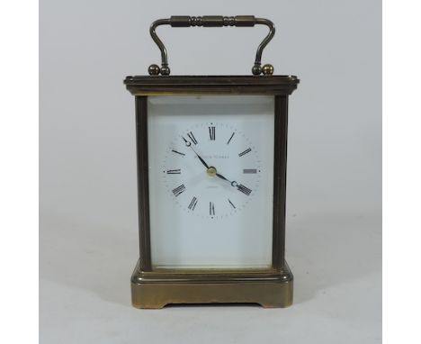 A brass cased carriage clock, with a white enamel dial, by Matthew Norman, 17cm tall