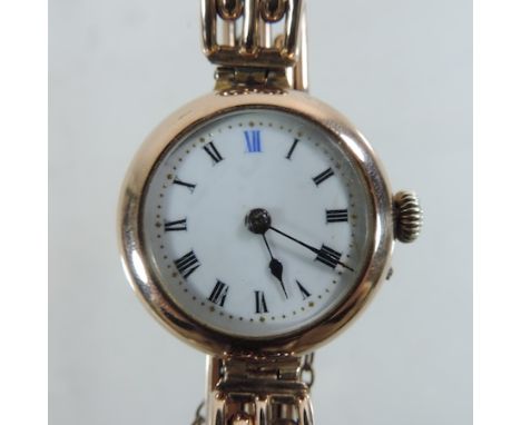 An early 20th century 9 carat gold cased ladies wristwatch, with a white enamel dial, on a flexible strap