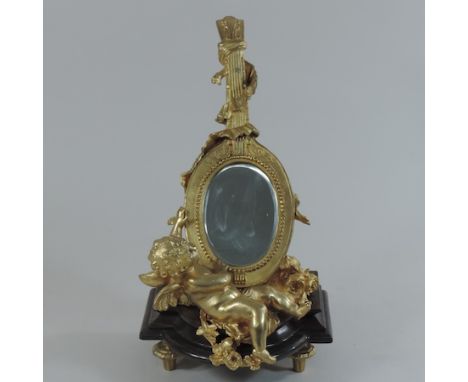 A gilt painted bronze mirror, in the form of a cherub and a lute, 30cm tall