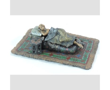 A reproduction cold painted bronze figure of a lady, reclining in bed, 15cm long