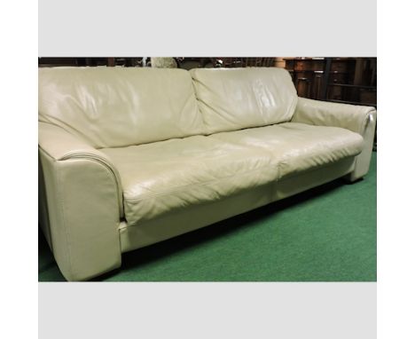 A modern cream leather upholstered three seater sofa
