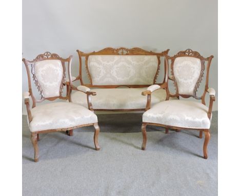 A late 19th century French cream upholstered show frame sofa, 131cm,  together with a pair of matching arm chairs