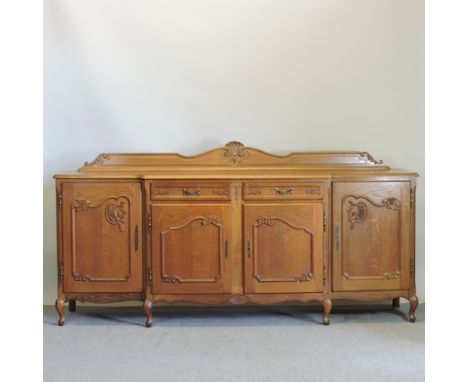 A French light oak breakfront sideboard, on cabriole legs, 220cm