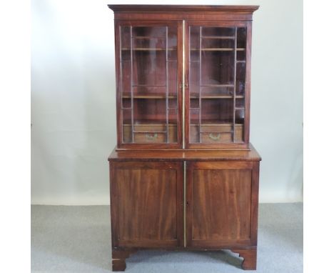A George III mahogany glazed bookcase, enclosed by panelled doors below, on bracket feet, 99cm