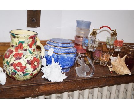 A shelf of glass, ceramics and others