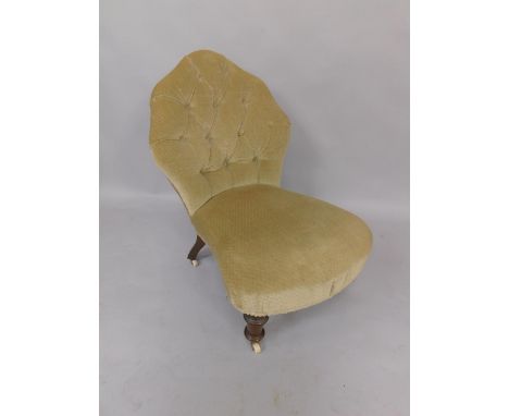 A Victorian spoon back nursing chair, with button back and overstuffed seat, raised on turned legs, brass capped on ceramic c