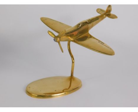 A brass model of a three blade propeller spitfire, on an oval base, 19cm long.