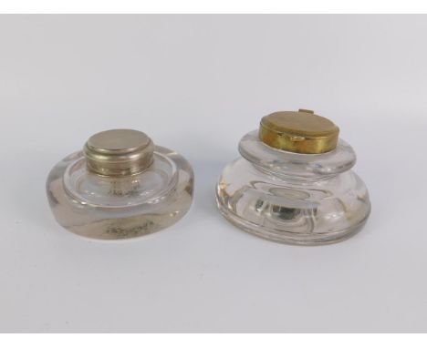 A Victorian cut glass inkwell with a brass hinged lid, 13cm diameter, and a similar inkwell with a plated lid, 12cm diameter,