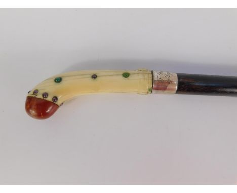 An early 20thC ebony walking stick with a jeweled ivory handle, silver ferule engraved 'T West Carnie, 59 Seymour Street', Lo
