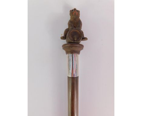 A Black Forest carved bear walking stick, modelled seated on a barrel, rosewood shaft with white metal ferule, 93cm long.