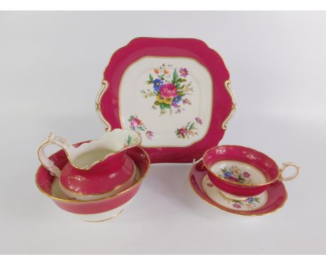 An early 20thC porcelain tea service printed with floral sprays, within a burgundy border, comprising cream jug, sugar bowl, 