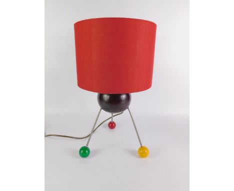 A retro atomic table lamp, formed as a lignum vitae bowl, raised on three metal rod legs and vari-coloured ball feet, with sh