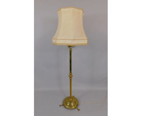 A Victorian brass standard oil lamp, converted to electricity, with a reservoir and turned column on a circular base and thre
