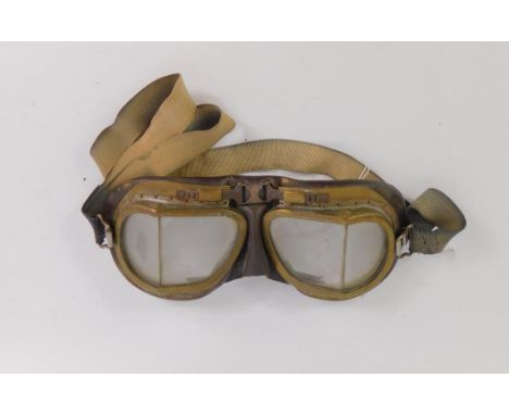 A pair of vintage brass and leather backed motoring goggles.
