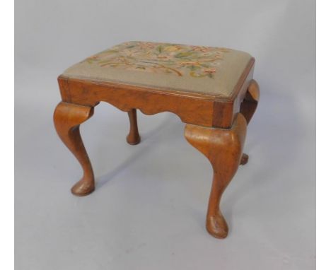 A George II style mahogany stool, with woolwork tapestry seat, raised on cabriole legs.