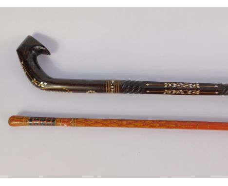 An Indian early 20thC rosewood and mother of pearl inlaid walking stick, 95cm long, together with a red lacquered cane, 101.5