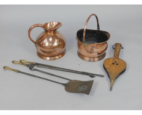 A copper helmet coal scuttle, three Victorian steel fire irons with brass handles, pair of oak bellows, and a copper jug.