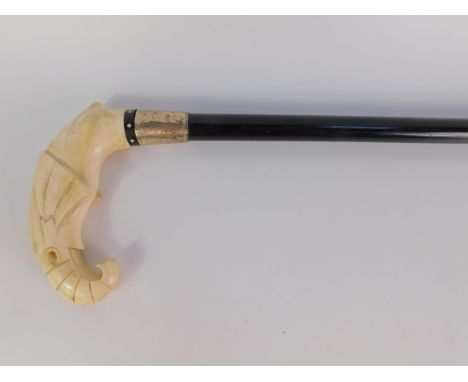 An early 20thC ebony and ivory walking stick, the handle carved as an elephant's head, silver ferule, foliate engraved, Birmi