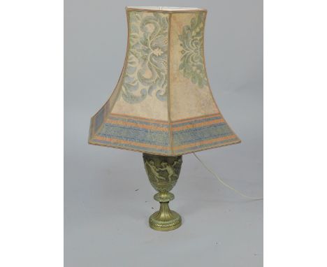 A brass table lamp, formed from an oil lamp base, embossed with dancing putti and rose garlands, within floral borders, with 