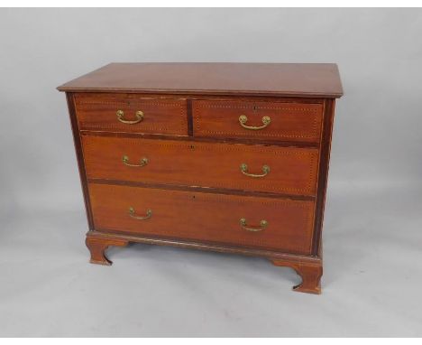 An Edwardian mahogany chest of drawers with barber's pole line inlay, two short over two long drawers, raised on ogee, bracke
