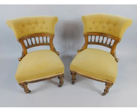A pair of Victorian mahogany tub nursing chairs, with button backs and overstuffed seats, raised on turned and channelled leg