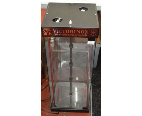 A revolving glass Mag-Lite display cabinet with light. 76cm tall.