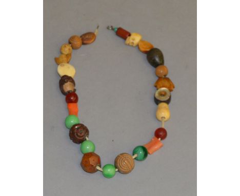 A netsuke and beaded necklace on string.