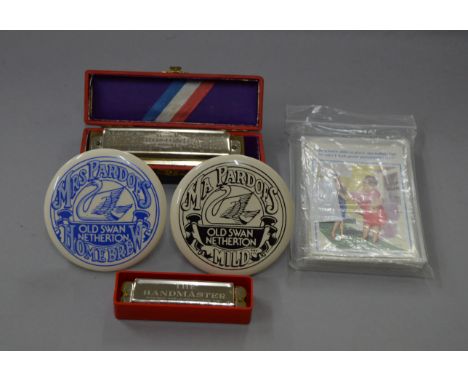 A mixed lot including 2 mouth organs, vintage comical postcards and beer pump cartouche.