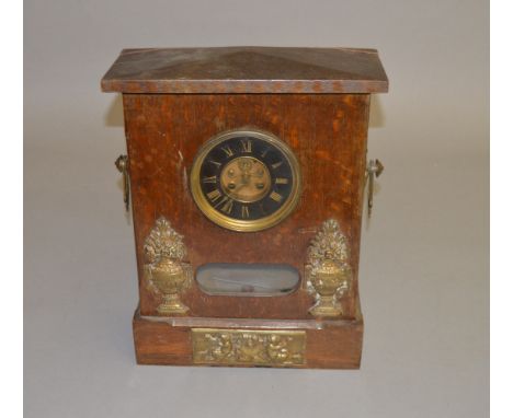 A wooden cased clock with brasswork decoration and pendulum. Movement marked AD. Mougin. 45cm tall.