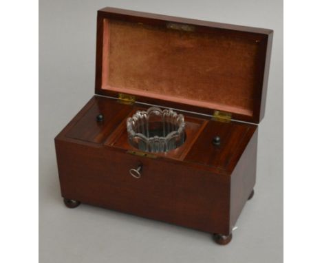 A Georgian mahogany tea caddy on bun feet with key.