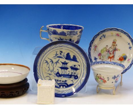 A CHINESE EXPORT TEA BOWL AND SAUCER, A FAMILLE ROSE SAUCERS, A LATER BLUE AND WHITE CUP AND SAUCERS, A CARVED WOOD STAND AND