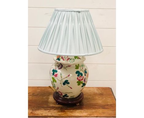 A Chinese lamp base with green shade and wooden base 