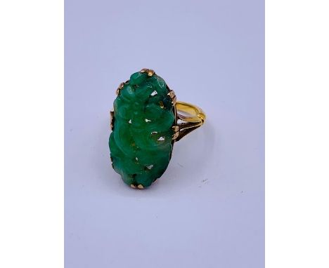 A Chinese jade ring on gold band with indistinct hallmarks 