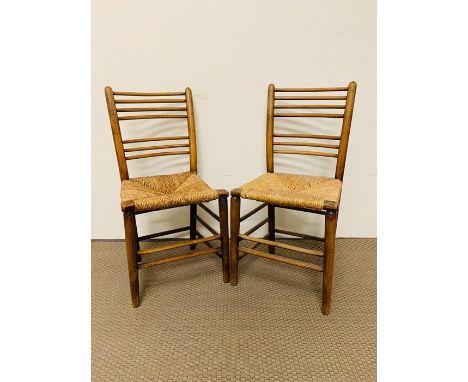 A pair of ladder back chairs with rush seats 