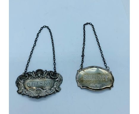Two silver decanter labels, one repousse with the word "whisky" and the other cut card with the words "sherry"