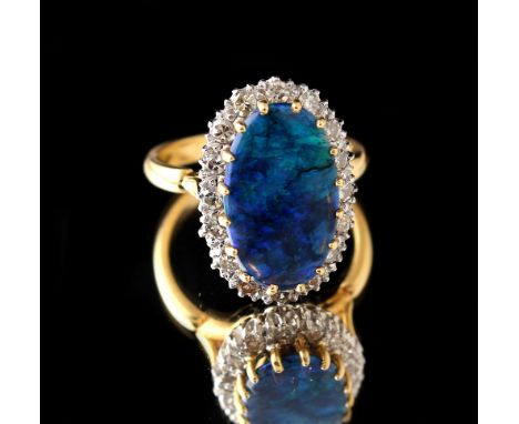 An 18ct yellow gold black opal &amp; diamond ring, the oval black opal measuring approximately 16.8 by 10.4mm, set within a b