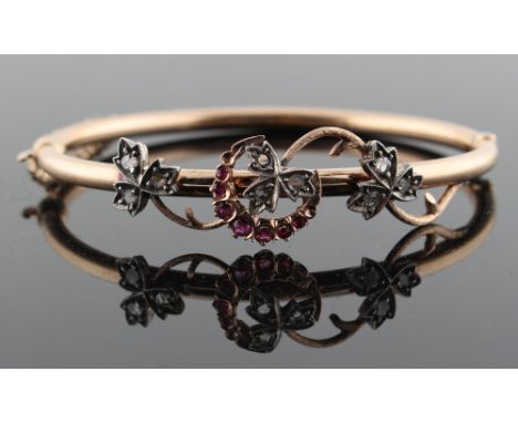 An attractive late Victorian unmarked yellow gold ruby &amp; diamond hinged bangle, with scrolling leaf &amp; crescent decora