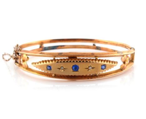 Property of a deceased estate - an Edwardian 9ct gold hinged bangle set with two small diamonds &amp; three round cut blue 's