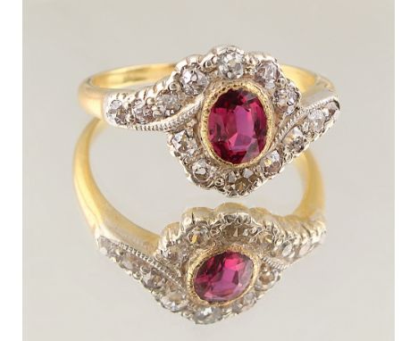 A late 19th / early 20th century 18ct yellow gold ruby &amp; diamond ring, of oval crossover form, the oval cut ruby weighing