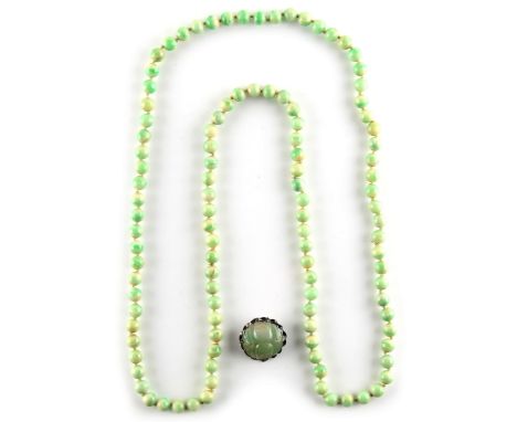 Property of a lady - a Chinese carved jadeite floral button brooch, with apple green inclusions, the jadeite approximately 28