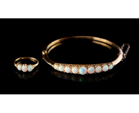 Property of a lady - an Edwardian 18ct yellow gold opal &amp; diamond hinged bangle, the nine graduated round fiery opals fla