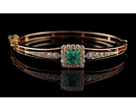 A late Victorian unmarked yellow gold emerald &amp; diamond hinged bangle, the certificated octagonal cut Colombian vivid gre