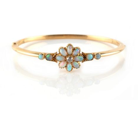 A late Victorian yellow gold opal &amp; diamond hinged bangle, the flowerhead setting with a central old cut diamond flanked 