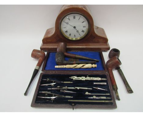 An Edwardian mantel clock with cased geometry set, some pipes and a carved bone item