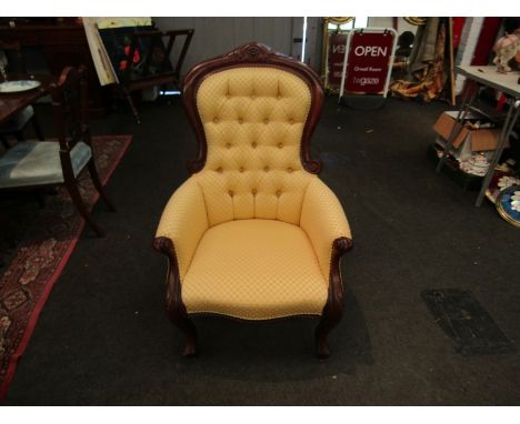 A Victorian spoon button back armchair with silk upholstery
