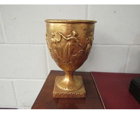 A tall gilt metal candlestick and a gilt chalice with dancing figures (2)
